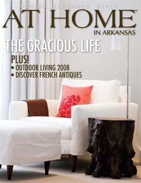 At Home magazine cover featuring a white chair, ottoman, and wooden table.