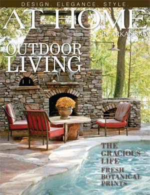 Stone outdoor living space with fireplace, seating, and pool.