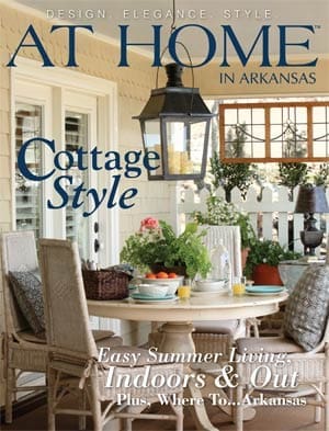 Cottage-style porch with a lantern, table, and plants.