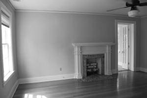 Gray wall with white fireplace and doorway.