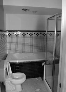 Black and white tiled bathroom with bathtub and shower.