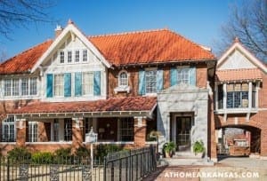 Two-story brick house with red tile roof and blue shutters.