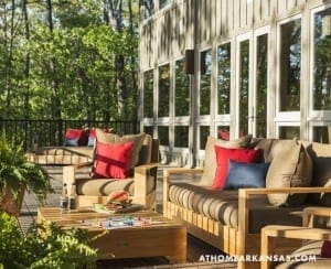 Wooden deck with seating, red cushions, and outdoor furniture.