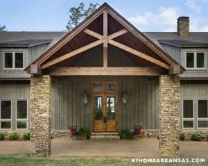 Stone and wood home entrance with a gable roof.