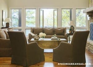 Large windowed living room with brown sofa and armchairs.