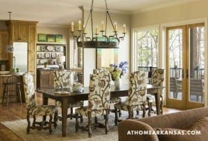 Large dining table with patterned chairs in a rustic kitchen.