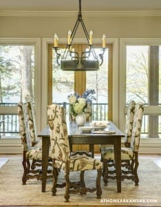 Dining table with patterned chairs and a chandelier.