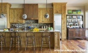 Rustic kitchen with wooden cabinets, stone backsplash, and a wooden island.