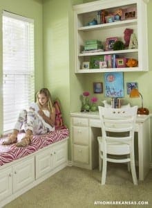 Green-walled bedroom with built-in desk and shelving.