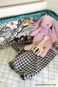 Pink corduroy and giraffe plush toys in a patterned basket.