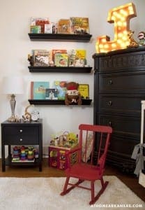 Black shelving unit with books and a vintage lamp.