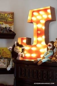 Large, illuminated wooden letter ‘T’ with warm-toned lights.
