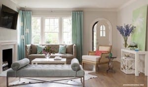 Living room with gray bench, sofa, and light wood floors.