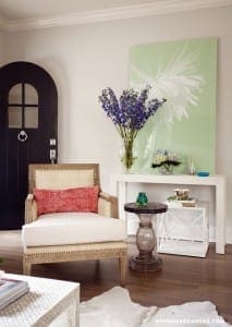 White chair, console table, and artwork in a light-filled room.