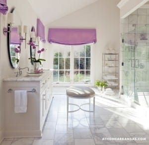 White marble bathroom with purple accents and a large window.