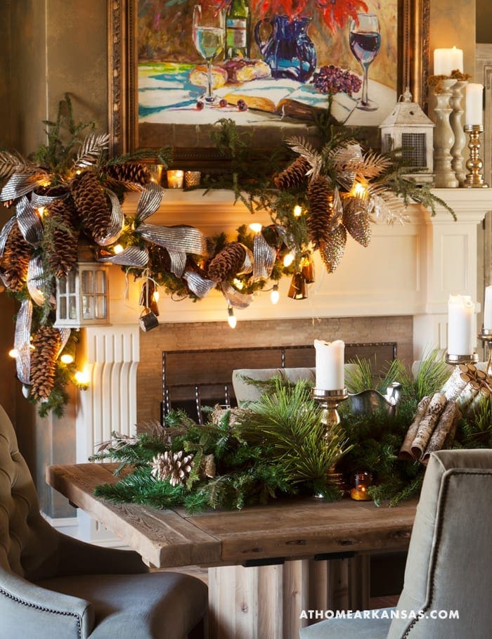 Mantel decorated with pinecones, greenery, and candles.
