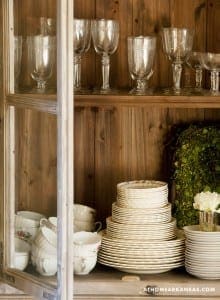 Wooden cabinet with glassware, plates, and china.