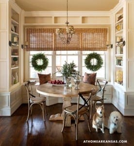 Cream-colored built-in shelves with wicker blinds and wreaths.