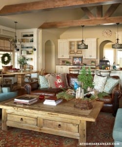 Large, rustic coffee table with leather sofa and holiday decor.