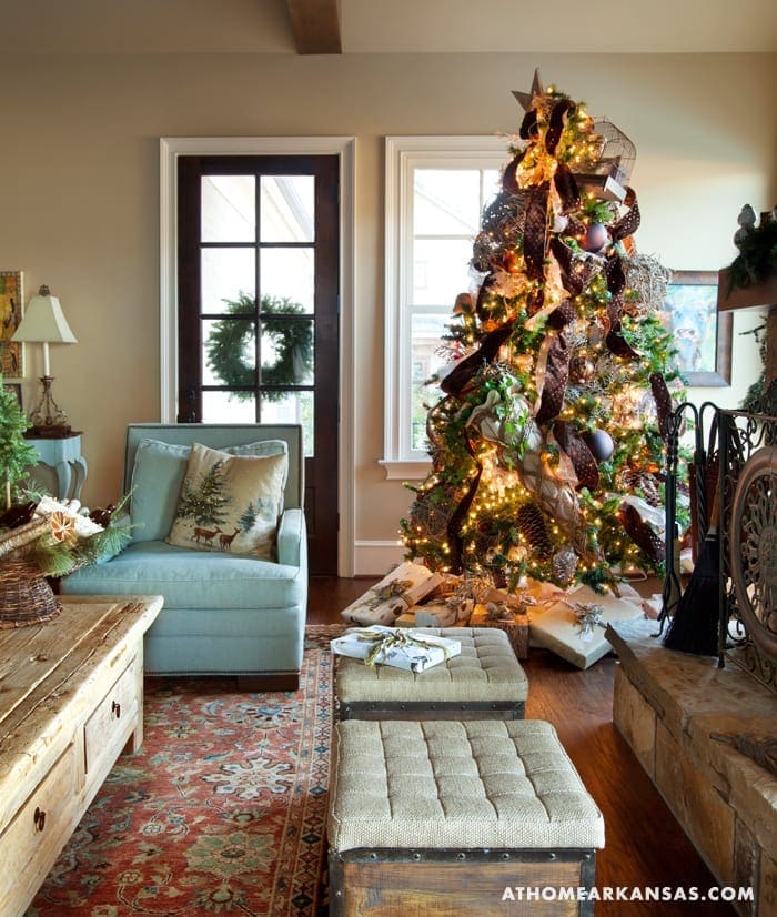 Blue sofa, rustic bench, and decorated Christmas tree in a living room.