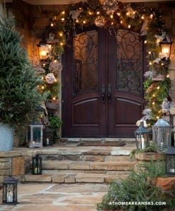 Stone entryway with arched doors, string lights, and lanterns.