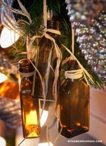 Brown bottles with twine hanging from a Christmas tree.