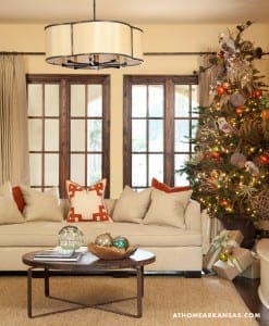 Living room with a large window arrangement, sofa, and Christmas tree.