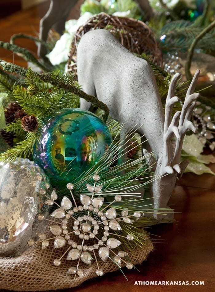 Gray reindeer statue with antlers, greenery, and ornaments.
