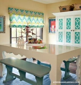 White table and benches with teal upholstery in a playroom.