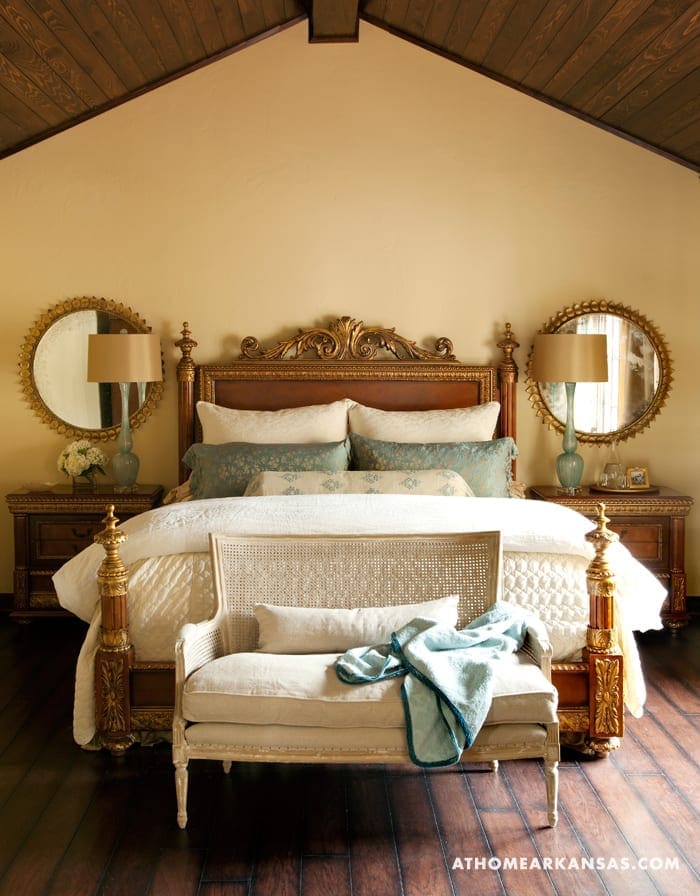 Cream-colored bedroom with wooden ceiling and ornate bed.