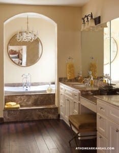 Bathroom vanity with marble countertop, chandelier, and mirror.
