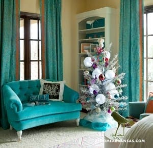 Turquoise sofa with orange accents and a decorative Christmas tree.