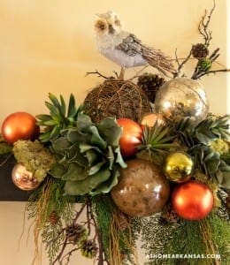 Decorative arrangement with owl, ornaments, and greenery.