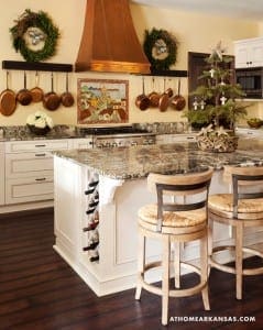 White kitchen island with granite countertop, copper cookware, and wine rack.