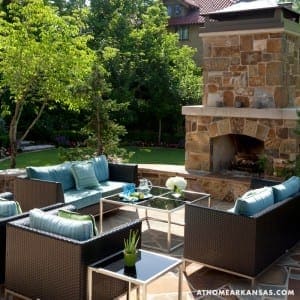 Stone patio with outdoor seating, fireplace, and landscaping.