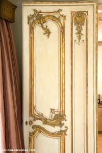 White door with gold detailing and ornate frame.