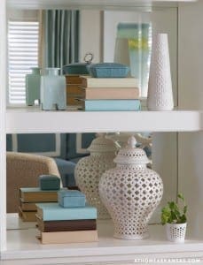 White cabinet shelves with books, vases, and decorative objects.