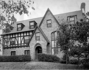 Brick Tudor-style house with gabled roof and dormers.