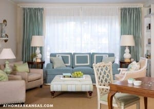 Light-blue sofa with teal curtains and two lamps.
