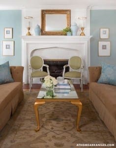 White brick fireplace with light blue walls, seating, and a rug.
