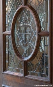 Dark wood door with stained-glass crest design.