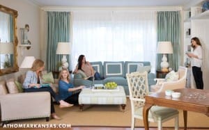 Living room with teal curtains, blue sofa, and three women.