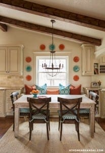 Kitchen with wooden beams, cabinets, and a breakfast table with chairs.