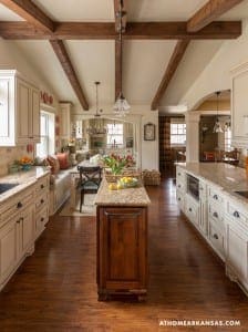 Large kitchen with exposed wooden beams and granite countertops.