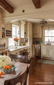 Cream-colored kitchen with wooden beams and a granite countertop.