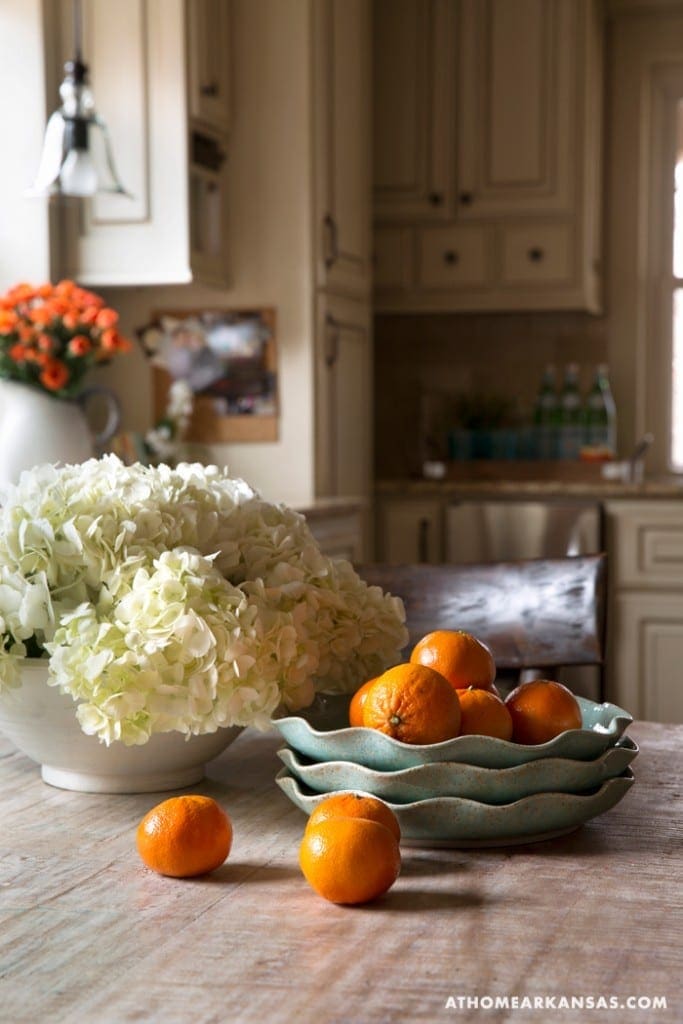 White hydrangea and orange tangerines on a wooden table.