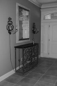 Black console table with wrought iron accents and a large mirror.