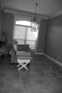 Gray room with a chandelier, window, and patterned tile floor.