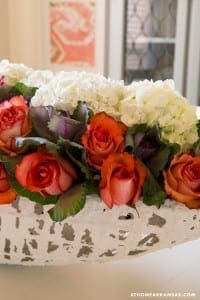 White birch container with roses and hydrangeas.