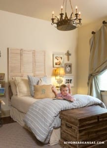 Small bedroom with a bed, dresser, and chandelier.